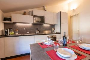 uma cozinha com uma mesa com pratos e copos de vinho em Piazza Anfiteatro- elegant apartment em Lucca