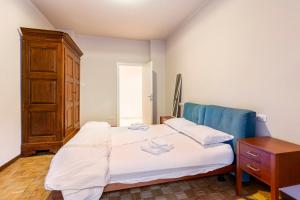 een kleine slaapkamer met een bed en een dressoir bij Appartamento Duomo - Voghera in Voghera