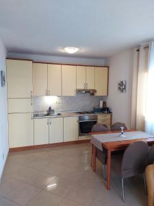 een keuken met witte kasten en een tafel en stoelen bij Apartment Ivan in Trogir