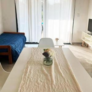 a room with a table with a vase of flowers on it at Te veo bien in Suipacha