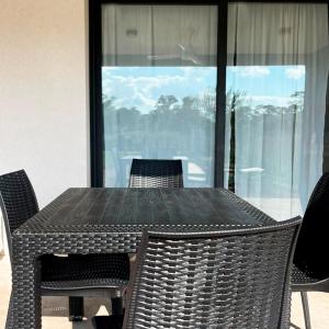 une table noire avec des chaises, une table et une fenêtre dans l'établissement Te veo bien, à Suipacha