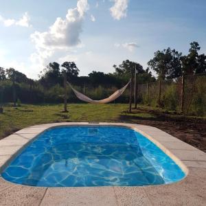 a swimming pool with a hammock in a yard at Te veo bien in Suipacha