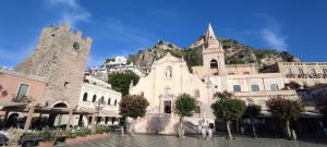 an old building with a mountain in the background at Blu Home Deluxe Taormina in Taormina