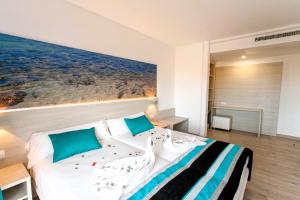 una camera da letto con un letto e un dipinto sul muro di Hotel Fenix a El Arenal