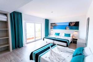 una camera d'albergo con due letti e un divano di Hotel Fenix a El Arenal