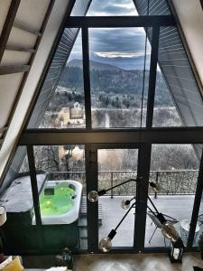 a bathroom with a large window with a bath tub at Jahorina Luxury Chalets in Jahorina