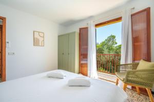 a bedroom with two beds and a balcony at Ses Savines Beach cala Llombards in Santanyi