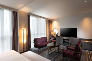 a living room with a couch and a television at DoubleTree by Hilton Kyoto Station in Kyoto