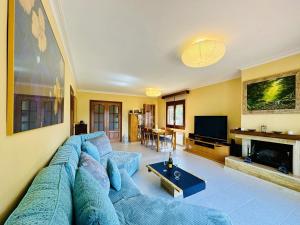 a living room with a blue couch and a television at Armonia Costabravasi in Santa Cristina d'Aro