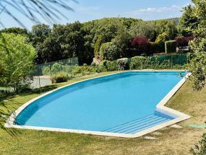 a large blue swimming pool in a yard at Armonia Costabravasi in Santa Cristina d'Aro