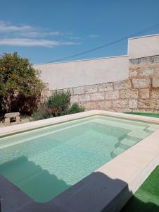 einen Pool vor einer Steinmauer in der Unterkunft Can Forner in Maria de la Salut