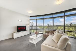 a living room with a couch and a tv at Green View 2B2B Olympic Park in Sydney