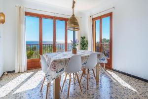 a dining room with a table and chairs with a view at Ses Savines Beach cala Llombards in Santanyi