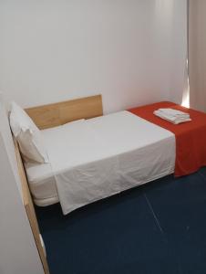 sypialnia z dużym łóżkiem z czerwonym i białym kocem w obiekcie Al-Xelb guesthouse w mieście Silves