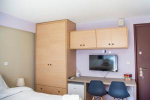 a bedroom with a desk and two blue chairs at Aesthetic Studio in Patra