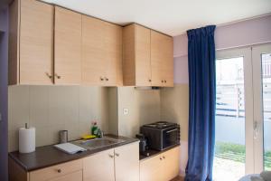 a small kitchen with a sink and a microwave at Aesthetic Studio in Patra