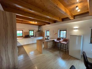a large kitchen with wooden ceilings and wooden floors at Holiday Home Planina in Tržič