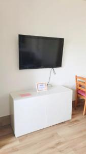 een flatscreen-tv op de top van een witte tafel bij BENALBEACH RESORT NEW APARTMENT - Benalmádena Málaga in Benalmádena