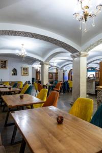 a restaurant with wooden tables and yellow chairs at Mahdia - Baghdadi - Laourient Apartments, restaurant, café in Mahdia