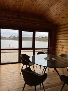 een eetkamer met een tafel en stoelen en een groot raam bij Добрий Хутор in Sukhyy Lyman