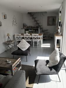 ein Wohnzimmer mit einem Sofa, Stühlen und einem Tisch in der Unterkunft Villa les Maguettes in Le Crotoy