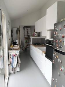 eine Küche mit weißen Schränken und einem Kühlschrank in der Unterkunft Villa les Maguettes in Le Crotoy