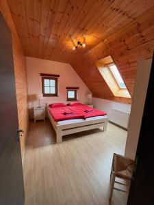 een slaapkamer met een rood bed op zolder bij Holiday Home Planina in Tržič