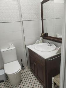 a bathroom with a sink and a toilet and a mirror at Casa Tagore in Utrera