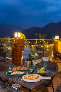 a table with two plates of food on a balcony at Shore by SHIVAYA in Rishīkesh