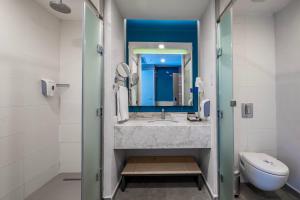 un bagno con lavandino, WC e specchio di Long Beach Alanya - Ultra All Inclusive ad Avsallar