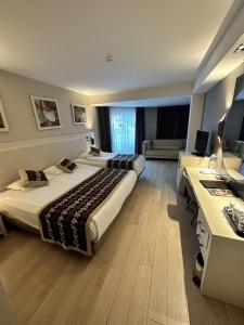 a hotel room with two beds and a desk at Long Beach Alanya - Ultra All Inclusive in Avsallar