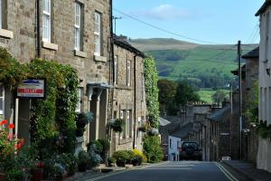 an empty street in a village with houses at Norwood Cottage in Kirkby Lonsdale