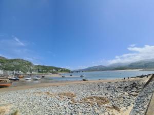 a sandy beach with boats in the water at The Penthouse NY Loft Apartment in Barmouth