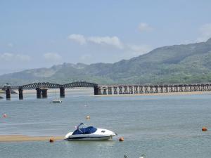a boat on the water with a bridge in the background at The Penthouse NY Loft Apartment in Barmouth