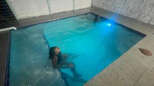 a woman swimming in a swimming pool at The Legacy Airbnb in East London