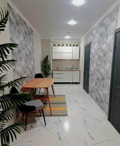 Una sala de estar con una mesa y una cocina. en ZhanHotels, en Almaty