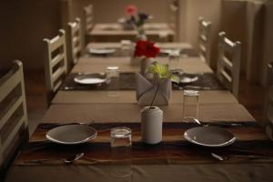einen Tisch mit leeren Tellern und Utensilien auf dem Tisch in der Unterkunft Hill View Resort Munnar in Anachal