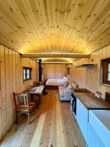Shepherds Hut/Hot Tub Private Lake Jurassic Coast في بريدبورت: غرفة مع مطبخ وسرير في كابينة