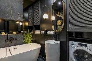 een badkamer met een bad en een wasmachine bij Charming Apartment for 4 people in Cracow by Renters in Krakau