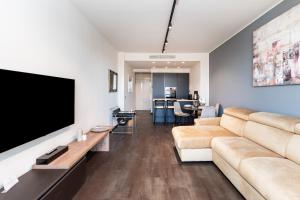 ein Wohnzimmer mit einem Sofa und einem Flachbild-TV in der Unterkunft Free Parking - Suite di Lusso nel Centro Storico con vista sulla città in Genua