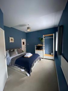 um quarto com uma cama e uma parede azul em Pershore Rooms at The Star em Pershore