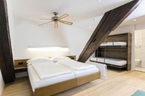 a bedroom with two beds and a ceiling fan at ROESLI Guest House in Lucerne