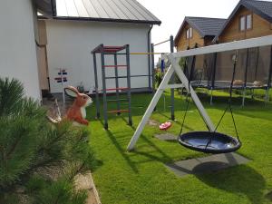 a toy rabbit is sitting next to a swing at Domki na Hamaku in Władysławowo