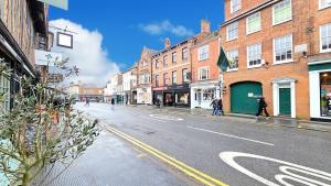 a city street with buildings and people walking down the street at Oakdale at Weavers Yard in Farnham