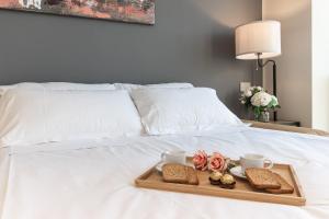 ein Tablett mit zwei Tassen und Keksen auf dem Bett in der Unterkunft Free Parking - Suite di Lusso nel Centro Storico con vista sulla città in Genua