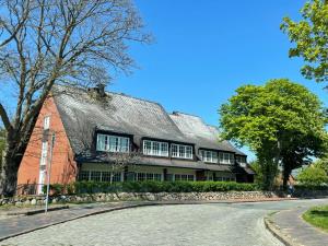 una casa de ladrillo rojo con techo gris en Stadler Kirchenweg en Westerland