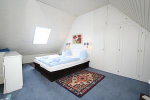 1 dormitorio con 1 cama y 1 alfombra en una habitación en Stadler Kirchenweg en Westerland