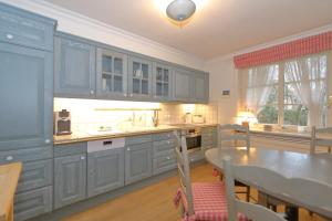 a kitchen with blue cabinets and a table and a dining room at Freesensün in Munkmarsch