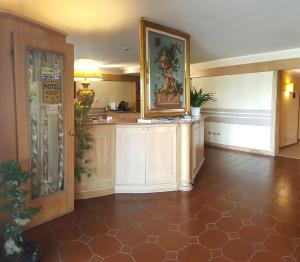 a lobby with a reception desk and a painting on the wall at Hotel Ascot in Binasco