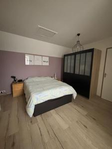 um quarto com uma cama grande e piso em madeira em Maison aux Portes de Paris em Vitry-sur-Seine